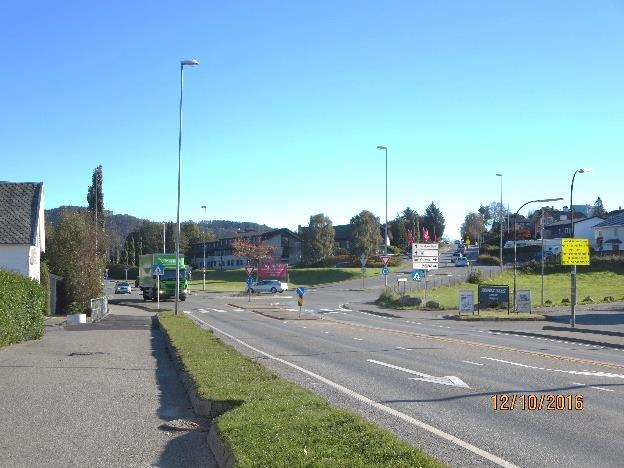 Figur 5-7 Kryss Stavangerveien-Roald Amundsens gate. Det er mer åpenhet langs Stavangerveien (venstre). Mellom store næringsbygg ligger skogholtet Håholen synlig (høyre).