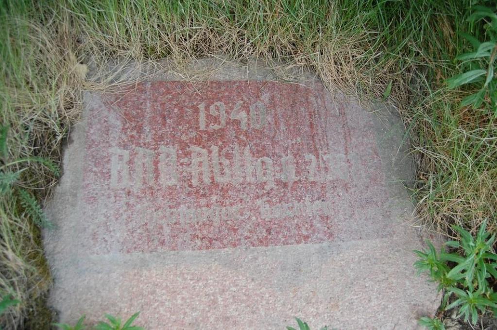 Omtrent midt på muren finnes ei minneplate i granitt med inskripsjon: «1940 RAD Abtlg k 2/362 hermagor kärnten» (oversatt til: 1940 ReichArbeitsDienst Abteilung k 2/362 fra distriktet Hermagor i den