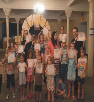 children for the morning's lesson. Lisps of Hebrew filled the room when a traditional Jewish scroll was presented and all ages tried their best to read the scriptural message upon it.