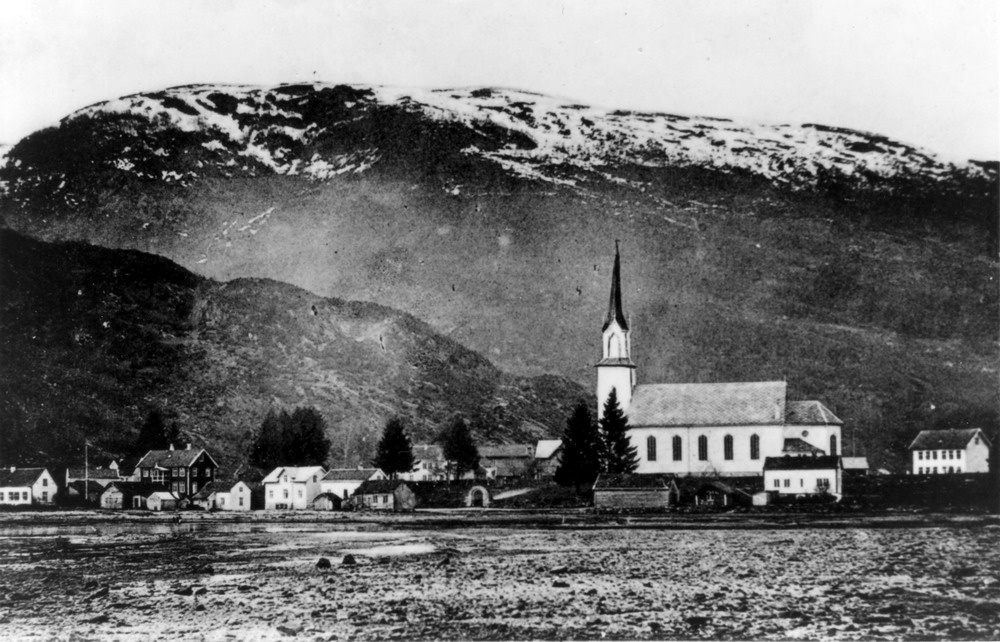 "10 Fjæra.jpg" Naustdal Kyrkje sto ferdig i 1891. Til høgre ser vi nyeskulen (1902). Huset til v. med ark er gamleskulen. Det mørke huset til v. er hotellet.