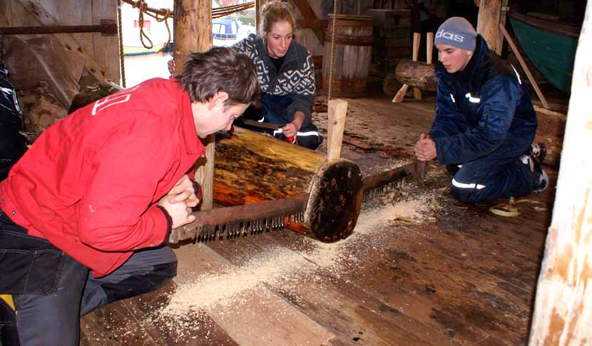 Ein lærling, ein ungdomsskuleelev og ein frivillig hjelpar på kystkultursenteret samarbeider om å byggja ein kopi av ein 150 år gammal færing (båt). Foto: Engøyholmen kystkultursenter 8.