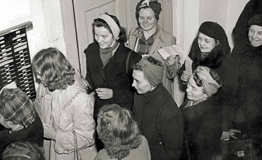 Arbeidere ved Nydalen Compagnie i kø foran stemplingsuret ved arbeidsdagens slutt, 1949.