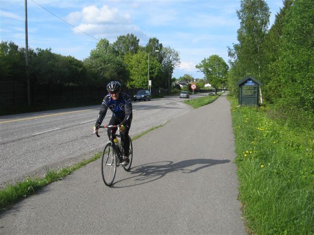 Snitt 15-3: Prinsippskisse for tiltak på den gamle jernbanelinja fra Linden Park til Kirkebakken, sett sørover. Jfr. bilde 15-3. Bilde 15-4: Busstopp nede i Gunnerødbrekka, sett nordover.