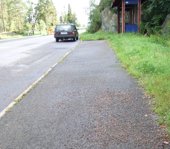 Linje: 401 Retning: Oslo Brånås skog Holdeplassen sett sydover ot bussboen. Orådet rundt lehuset er gjengrodd og lite innbydende for de reisende.