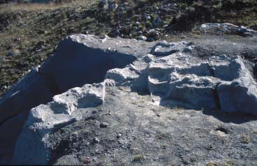 Figur 9 Serpentinittknollen ved Bubakkforekomsten sett mot nord. Delvis forvitrede grytespor sees i kleberstein og talkrik serpentinitt nederst mot vannpytten i forgrunnen.