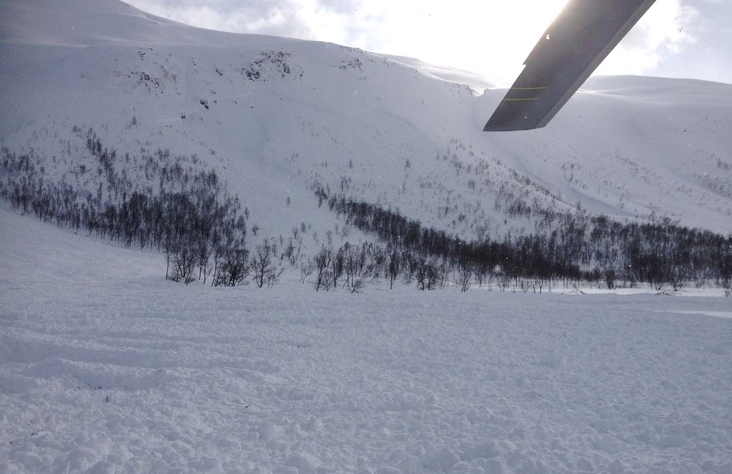 Oversiktskart med ulykkesstedet ca. 20 km vest for Tromsø angitt med rød markør. Ulykkesområdet antydet med rødt rett til høyre for ytterkant av meget store naturlig utløst snøskred som gikk 4. april.