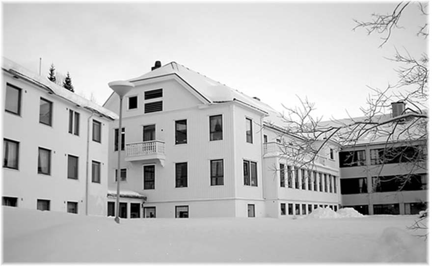 Tilbygget i hvit mur, fra 1978, er tegnet av arkitektene Ugland & Thorne. De lange, sammenhengende vindusrekkene har brunbeiset trebesetning i underkant.