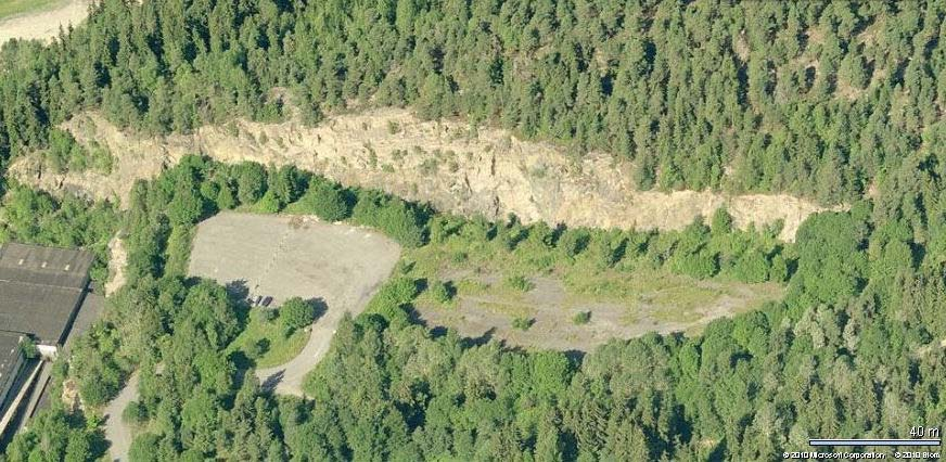 Vestveggen i øvre steinbrudd ved Stig, langs østsiden av Grefsenåsen, med store innsunkede stykker av eldre skorpebergarter i den fremtengende smeltemassen, som størknet til syenittbergarten