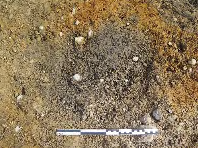 Rapport arkeologisk registrering 29 219370-14 Ildsted Idsted eller bunn av kokegrop. Ligger inn mot utvidet sjaktkant i N. Tilnærmet oval, men noe utflytende avgrensning i NØ, 190x120cm.