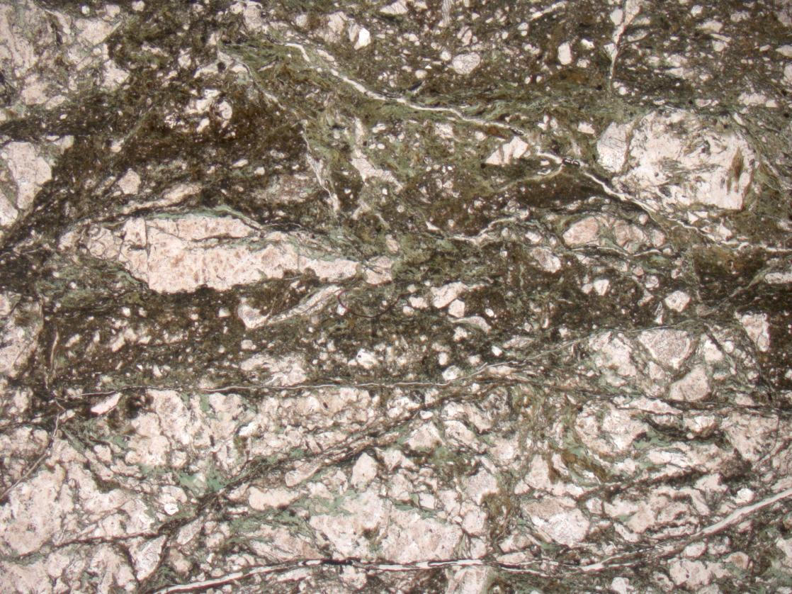 Figure 6.5. More evolved cataclastic texture, with mechanical comminution of feldspar. Note the significant amount of chlorite distributed predominantly along fractures and clast-clast interfaces.