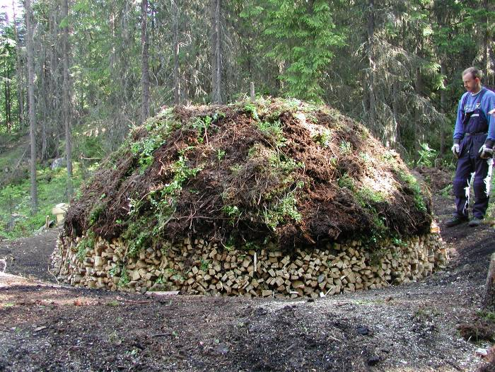 Tjærebrenning: Oppbygging av tjæremile med never og tyrived. Mila dekkast med torv før den vert kveikt. Foto: Kjell Marius Mathisen, Maihaugen temperatur på om lag 60 C.