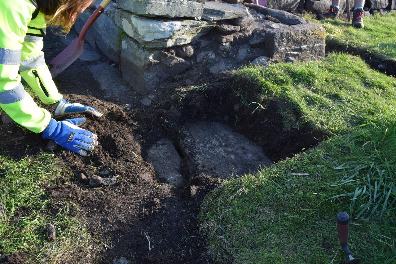 inngangspartiet ble det avdekket hellesteiner som dekket hele døråpningen (se figur 14). De ligger under inngangspartiets murverk og tyder på at de er samtidig med kirkebygget.