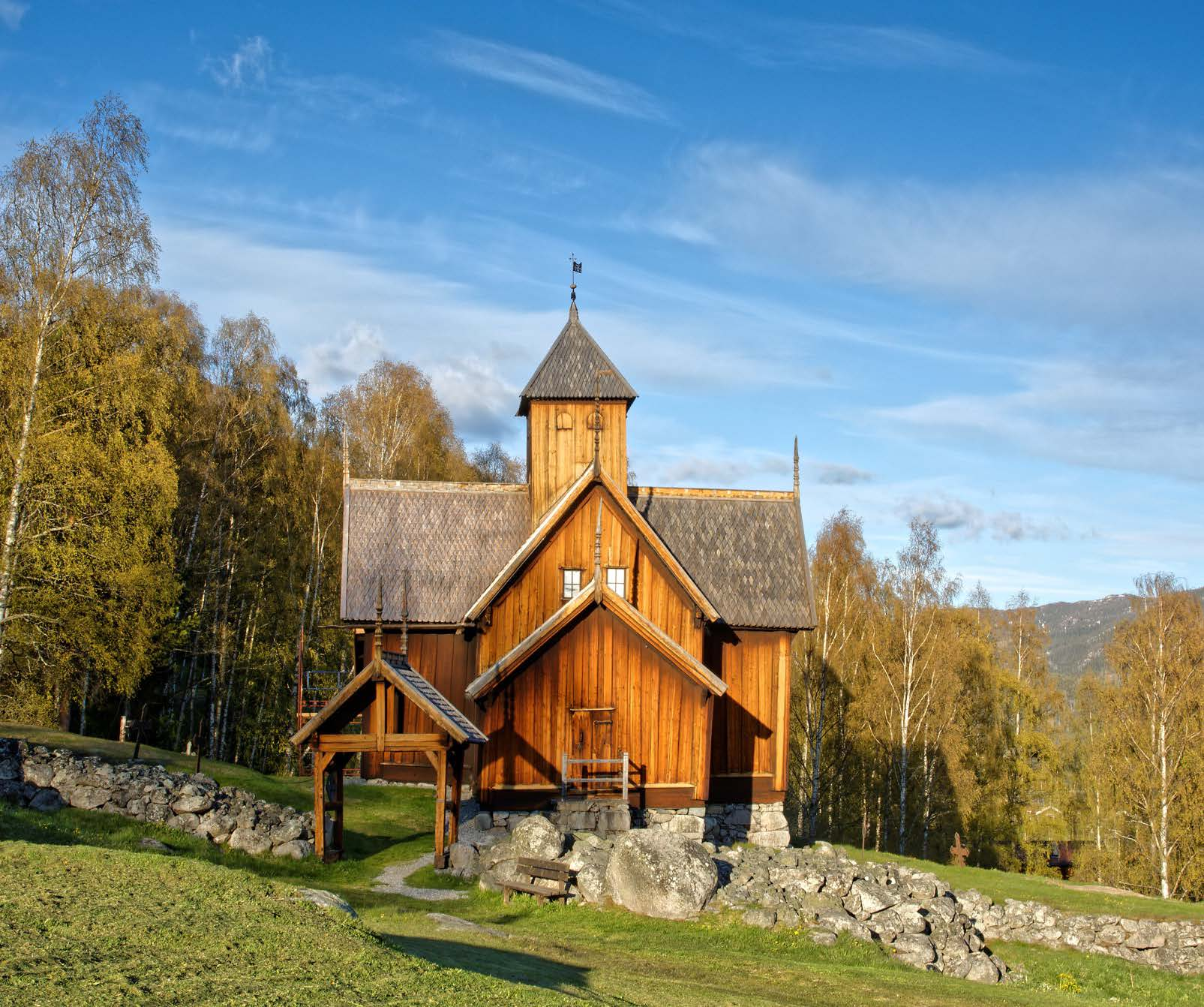 Stavkyrkja: Kyrkja med kyrkjegardsmur og kyrkjegardsportal sett frå vest. Foto: Dagfinn Rasmussen, Riksantikvarens arkiv.