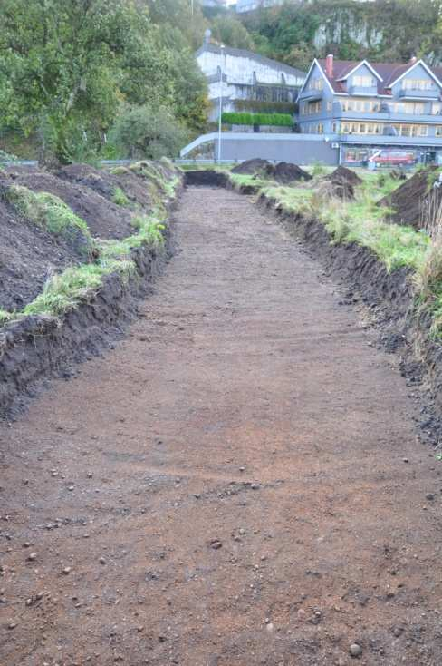 Sjakten ble beskrevet fra nord mot sør. 0-8 meter: rød sand med rullestein. I første del av sjakten lå det mye tegl, takstein og liknede bygningsmateriale i matjorden.