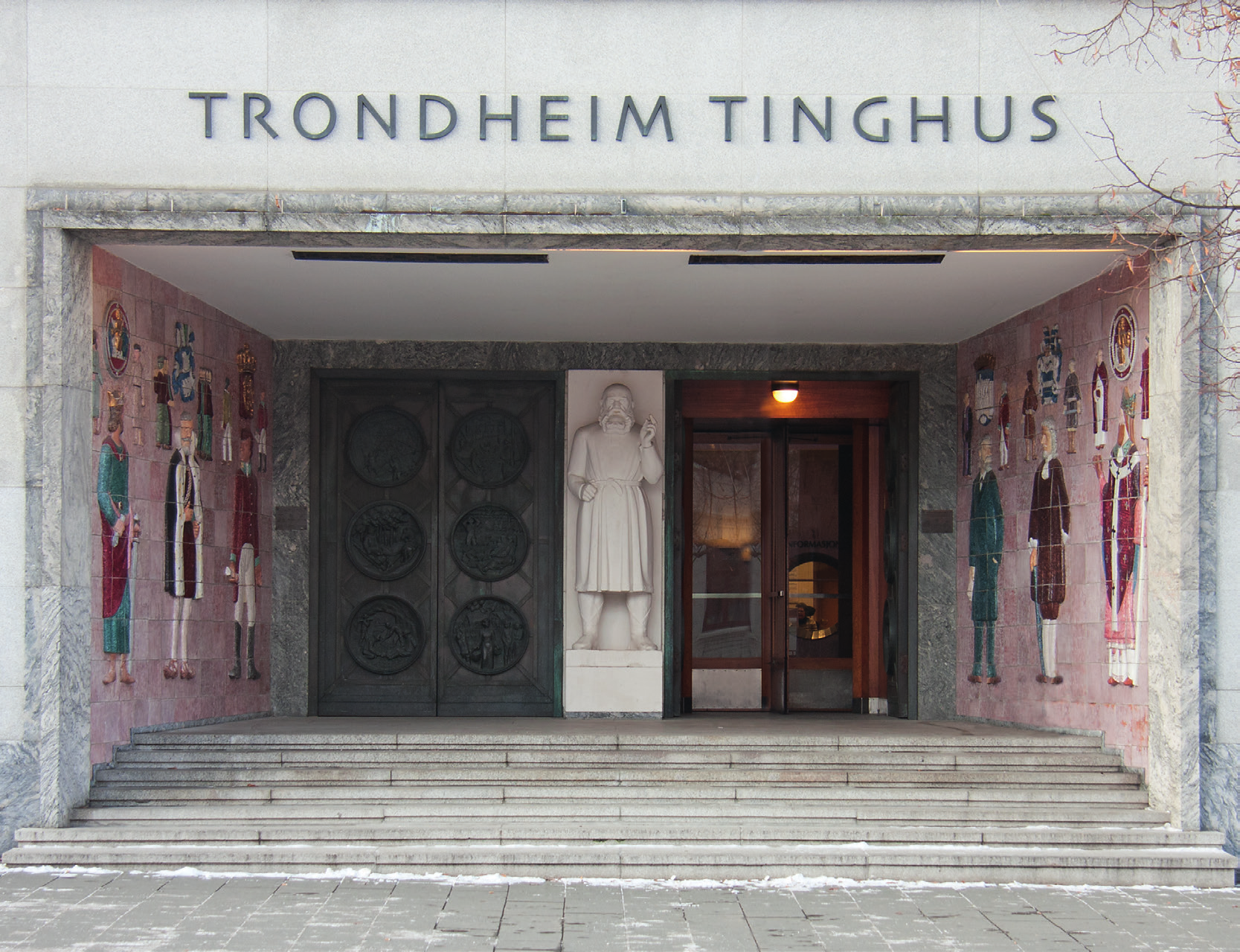 Inngangspartiet til Trondheim tinghus fra Munkegata har to dobbeltdører med i alt 12 relieffer med motiver fra samfunnet som domstolene har sitt virke i, trøndersk næringsliv, kirkeliv,