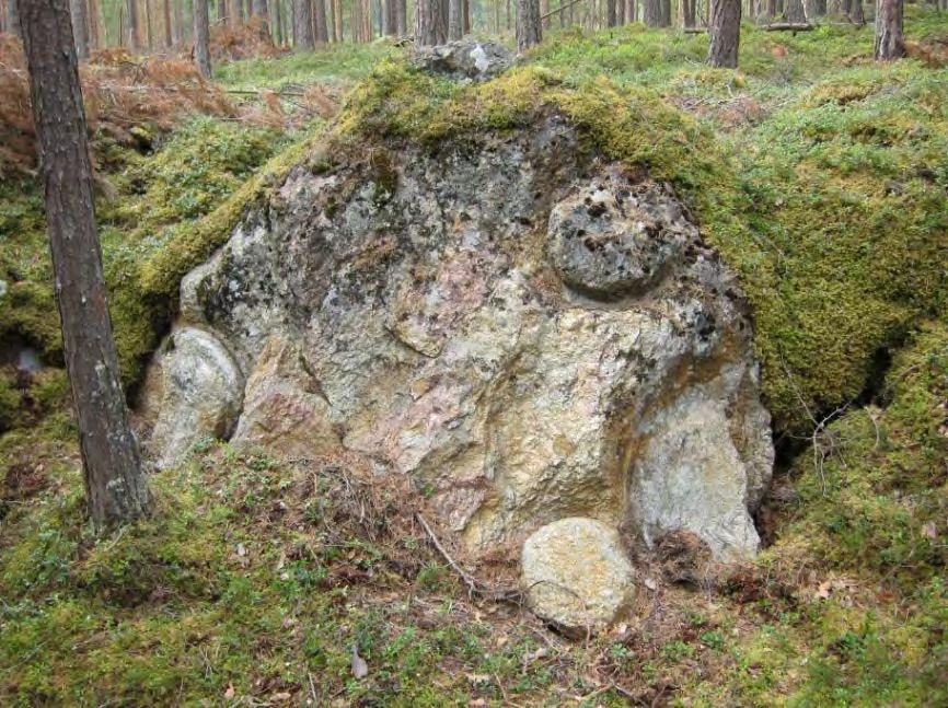Ved 016 (30 meter sør for Storgruva) er det rester av hogde kanaler til minst tre emner på en steinblokk som stikker et par meter opp fra bakken (Figur 68).