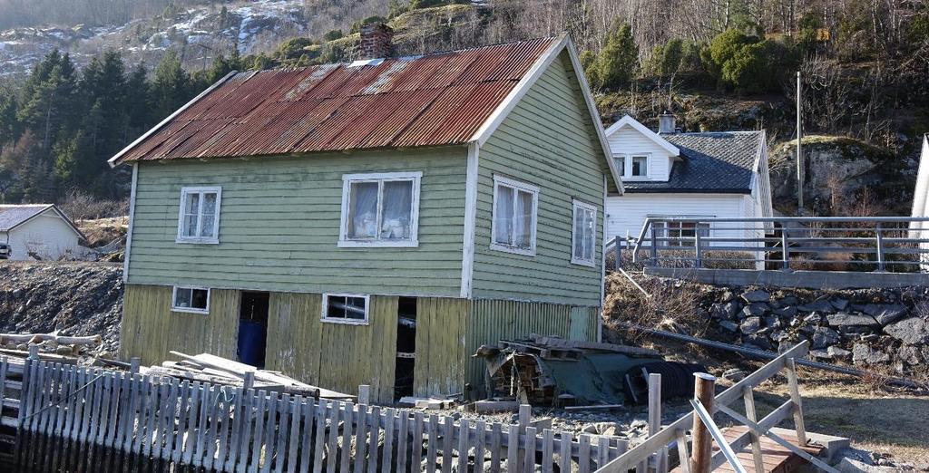 Bølgeblekk på taket, andre halvdel av taket er dekket med skifer. Inngang fra Rv.