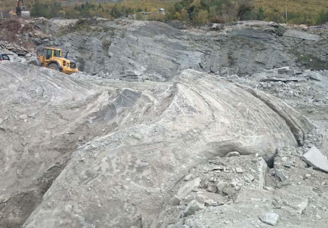 Innslag av kvarts-feldspatårer reduserer natursteinskvaliteten lokalt. B- Storskala tett folding av sandsteinen. Bildet er tatt like under (stratigrafisk) den vestlige natursteinssonen.