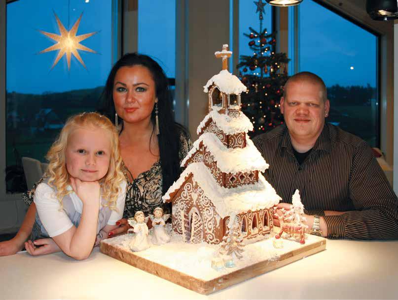 OVERRASKET OG GLADE: Familien Steen fra Sola fikk førstepris og 10 000 kroner for sitt pepperkakehus, en vakker stavkirke.