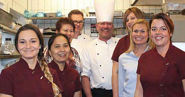 Sjefskokk, Ole Kristian flankert av en del av den glade arbeidsgjengen på Aarnes Kafeteria.