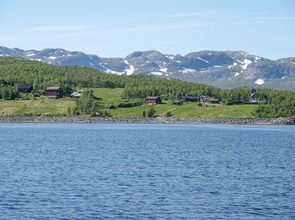 Bosetting på øya Hovden i Møsvatn, med kirken. Til høyre havna. Foto: Trond Taugbøl. 1000 jernvinneplasser rundt hele vannet, på øyene og nærliggende områder.