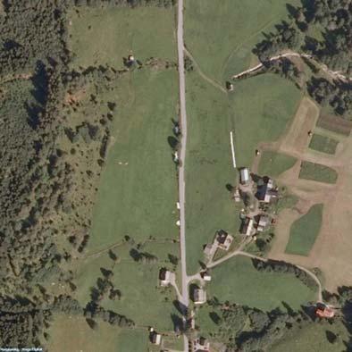 Figur 2. Flyfoto. Gjerde ligger på venstre side av Bavallsveien, og Trodo på høyre (foto fra Gislink.no). Figur 3. Oversiktsfoto over planområdet. Stikkene markerer veitraseen, sett mot SØ (foto C.