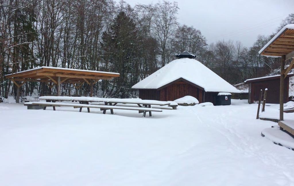 parkeringsplasser og nedgang til lavvoen over ei bro.