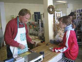 Oppgavene mine var å telle penger, ta imot og sette inn Helios varer, Nils Erik i Jevnakerbutikken. Foto: Jan Bang være imøtekommende mot kunder, vaske gulv, rydde og pusse vinduer.