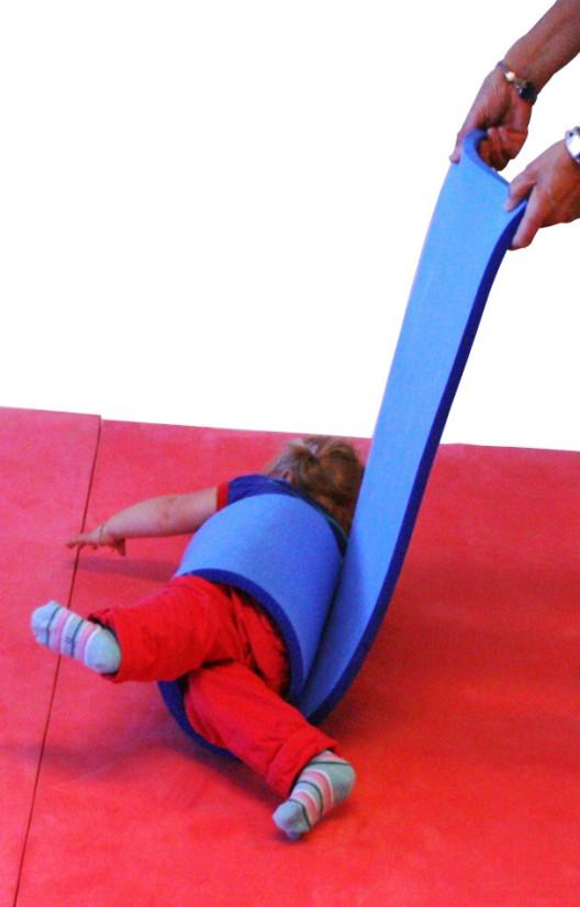 Rull barnet inn i matten og rull det ut igjen, slik at barnet får følelsen for bevegelsen.