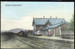 Oversikt over stasjonsområdet og hotellet med personalet på trappa i forgrunnen. (M. Andersen), stpl. Grua 1907, kv. 1-2. F 4211 1 HAMAR. Storflommen 1927 hindrer ikke toget å passere.