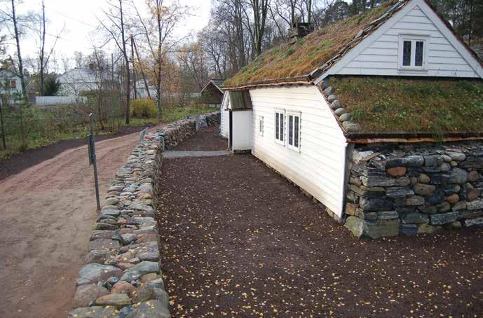 Muring av dobbel steingard på museet høsten 2014 nærmest Jan Høvo, Kjetil Sæterdal, Ida Løkken. Bak traktoren: Christian Winther-Larsen. Foto: Norsk Folkemuseum.