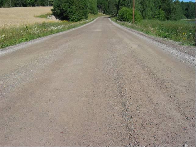 Tilstandsgrad 1 beskrives slik: Løs grus kan forekomme på og langs vegbanen, men kjørekomfort og sikkerhet påvirkes ikke i nevneverdig grad. Figur 14.7 Løs grus.