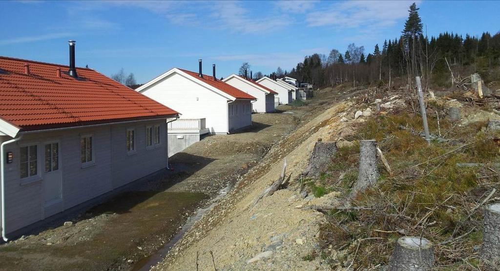 Figur 4: Tilgrensende bebyggelse og terrengtilpasning. Nybygde tomannsboliger i Østvoldvegen. Foto fra plangrense mot sør.