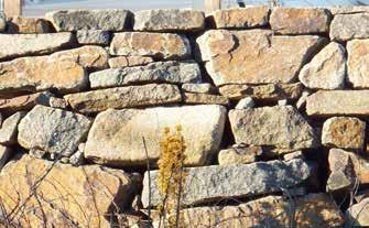 stakittgjerdet. Ny mur av kilt stein Ny mur av naturstein.