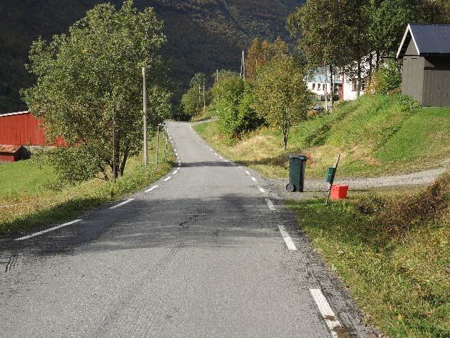 rad på oversida av vegen med tre separate innkjøringer, og driftsbygningen ligger tvers over vegen på nedsida.