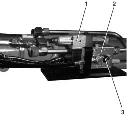 På hydraulikksylindrene for - bom (2), - skuffestikke (1) og - planeringsskjær (3) er det montert en rørbruddsikring (sikkerhetsventil) direkte på hydraulikkoblingen på sylinderen.