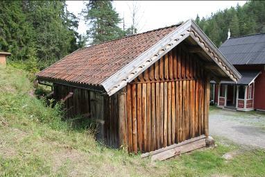 Bygget skiller seg ut med sin bunnramme og hjørnestolper i grovt rundt tømmer, vegger i stående honkledning, forskjøvet inn for