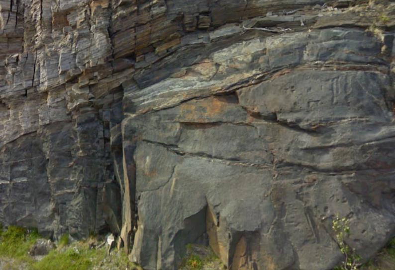 Linse av en mørkere gabbro Foto 6: Foto viser linse av gabbro. Foto er tatt i eksiterende bergskjæringen langs Ev69 nord for Skarvbergvika. 3.