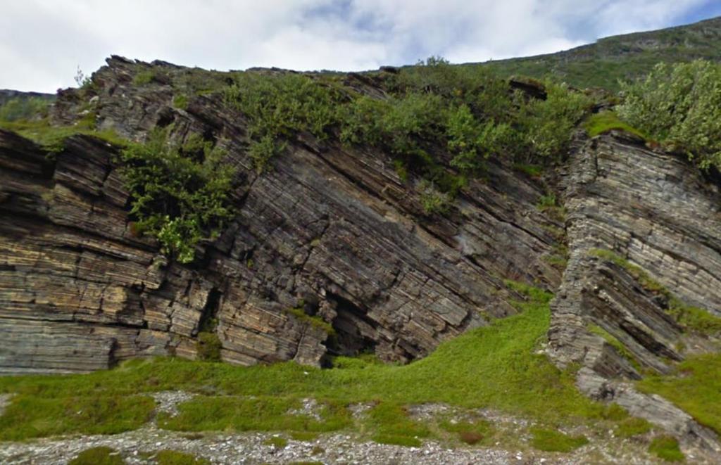 Foliasjon vil falle parallelt med planlagt bergskjæring Foliasjon vil falle innover i planlagt bergskjæring Foto 7: Foto viser stedvis folding i berggrunnen langs eksisterende veg ved Hønsa.