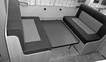 Løft bordplaten foran en god del opp og huk den på skrått ovenfra ned inn i de nederste holderne på veggen m.