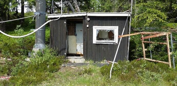 Pilene på kartet over viser bygningene som ønskes revet. I tillegg bør det lille bygget på bildet under fjernes. Dette bygget står i forbindelse med slalåmbakken.