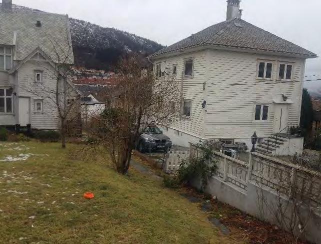 «Terrasse» av planeringsmasser. Stien til høgre i bildet er trolig den opprinnelige tilkomstvegen til bolighuset. Ved Schweigårds vei 24 er det en eldre enkel garasje med saltak.