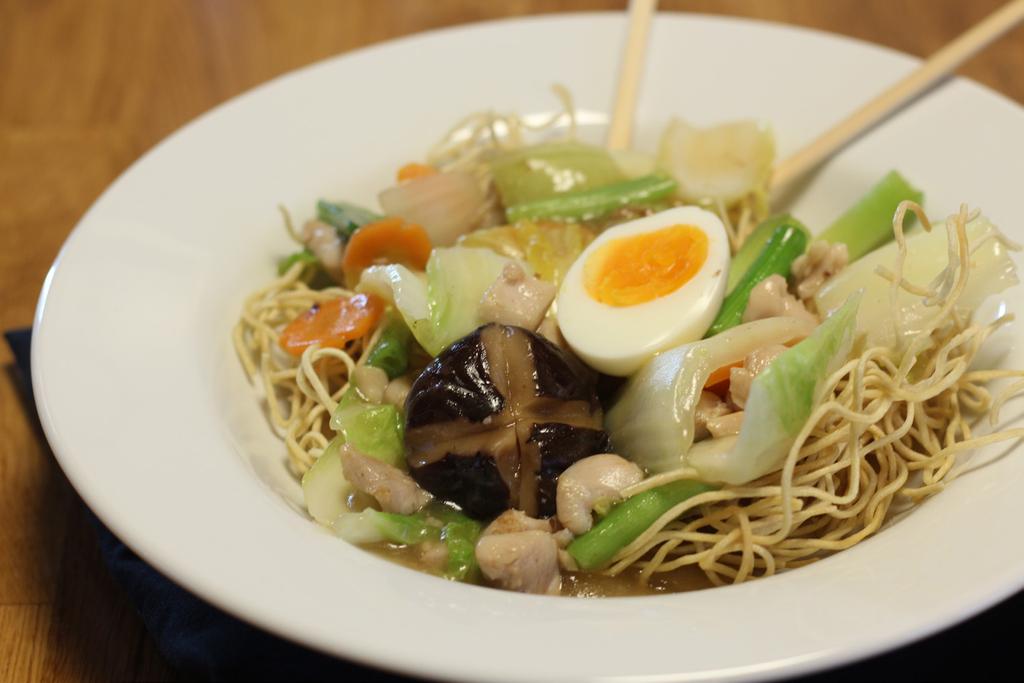 eggnudler toppet med japansk chop suey og egg.