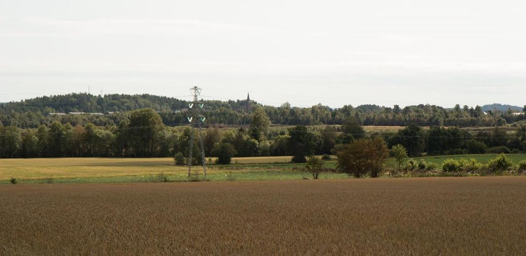 Figur 10 Stokke kirke midt i bildet mot SSØ, sett fra ståsted N for planområdet. Foto: Norconsult.