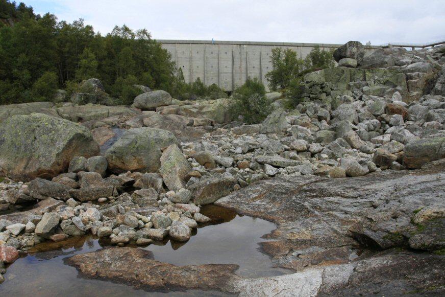 Figur 6-11. Dam Langevatn sett fra elva Monn like nedstrøms. Foto: F. Gravem, Sweco. Figur 6-12. Jettegryter i elva Monn oppstrøms Tjønna.