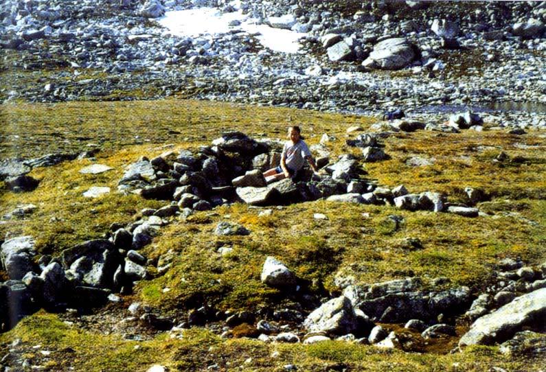 Artikkelforfattaren, som og er leiar i fangstminnegruppa i Nesset, sit i ei av dyregravene ved Trollvassosen. Elva frå Trollvatnet ser me i bakgrunnen Foto: Dag Ringstad.