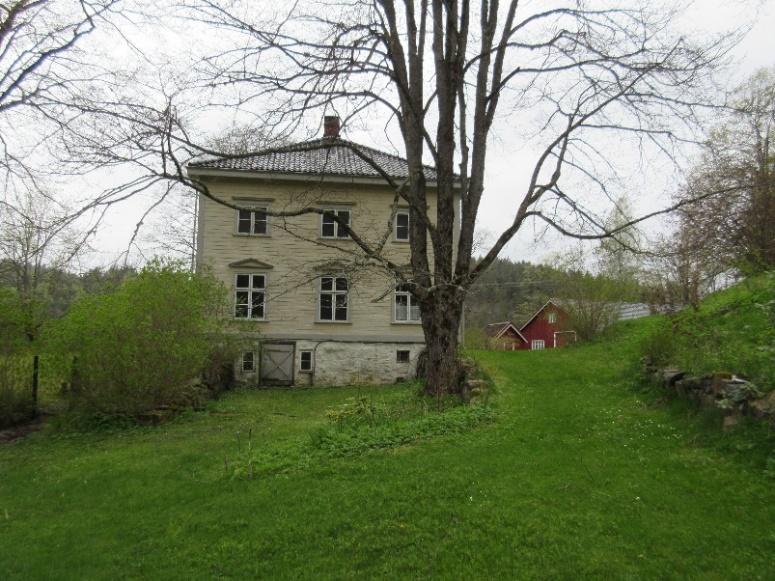 Mot huset går det to parallelle natursteins forstøtningsmurer, én langs veien fra gårdsplassen videre østover ned mot Fantegata og bærhagen, og én mur som tar opp terrenget fra prydhagen foran huset.