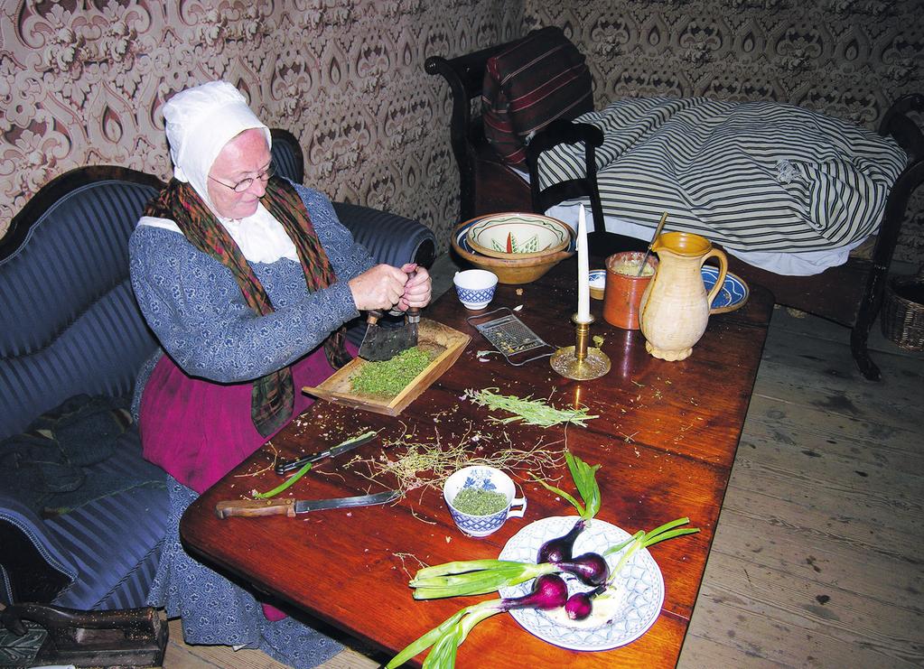 Dramatiseret museumsformidling 117 Fig. 3. Skomagermadammen laver krydderfedt. Foto: Den Gamle By, 2008. stiger op fra ildstedet, står en stegepande på et stykke trekantet jern.