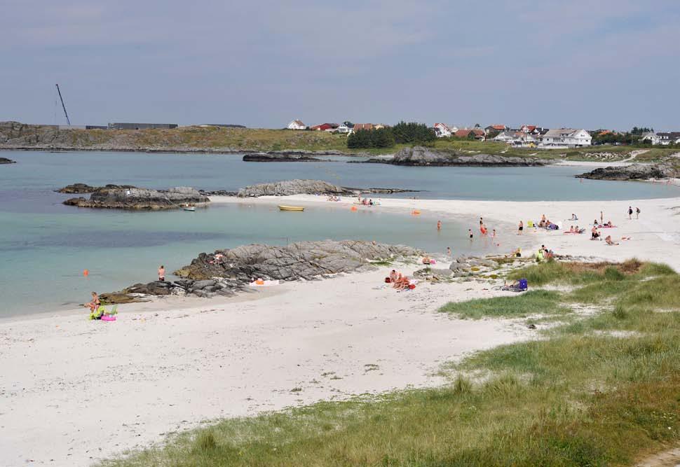 Figur 261. Sandstrender på Ådland og Medhaug. Sandtunga som går ut til dei to Medhaugsholmane blir kalla ein tombolo. Nemninga blir brukt om ei landtunge av sand som forbinder øyer med fastlandet.