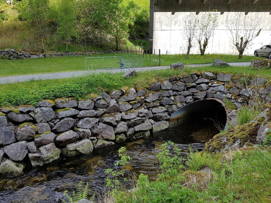 anlagt. Eksisterende stasjonsbygning skimtes bak trærne.